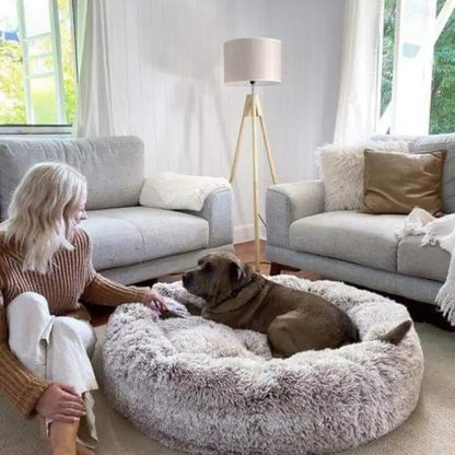 Dog laying on fluffy dog bed in light grey color